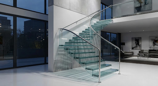 Escalera residencial de lujo con peldaños flotantes de vidrio y pasamanos continuo de acero inoxidable.